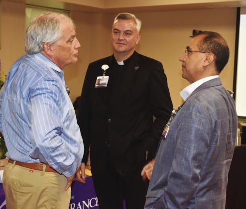 NEW PRIEST —Father Justin Wylie (center) was welcomed Tuesday at a reception in his honor by CHRISTUS Mother Frances-Sulphur Springs CEO Paul Harvey (left) and Andy Navarro, Vice-President of Mission Integration for CHRISTUS. Fr. Wylie will serve from the Sulphur Springs office as Pastoral/Spiritual Care Program Manager. Staff photo by Don Wallace